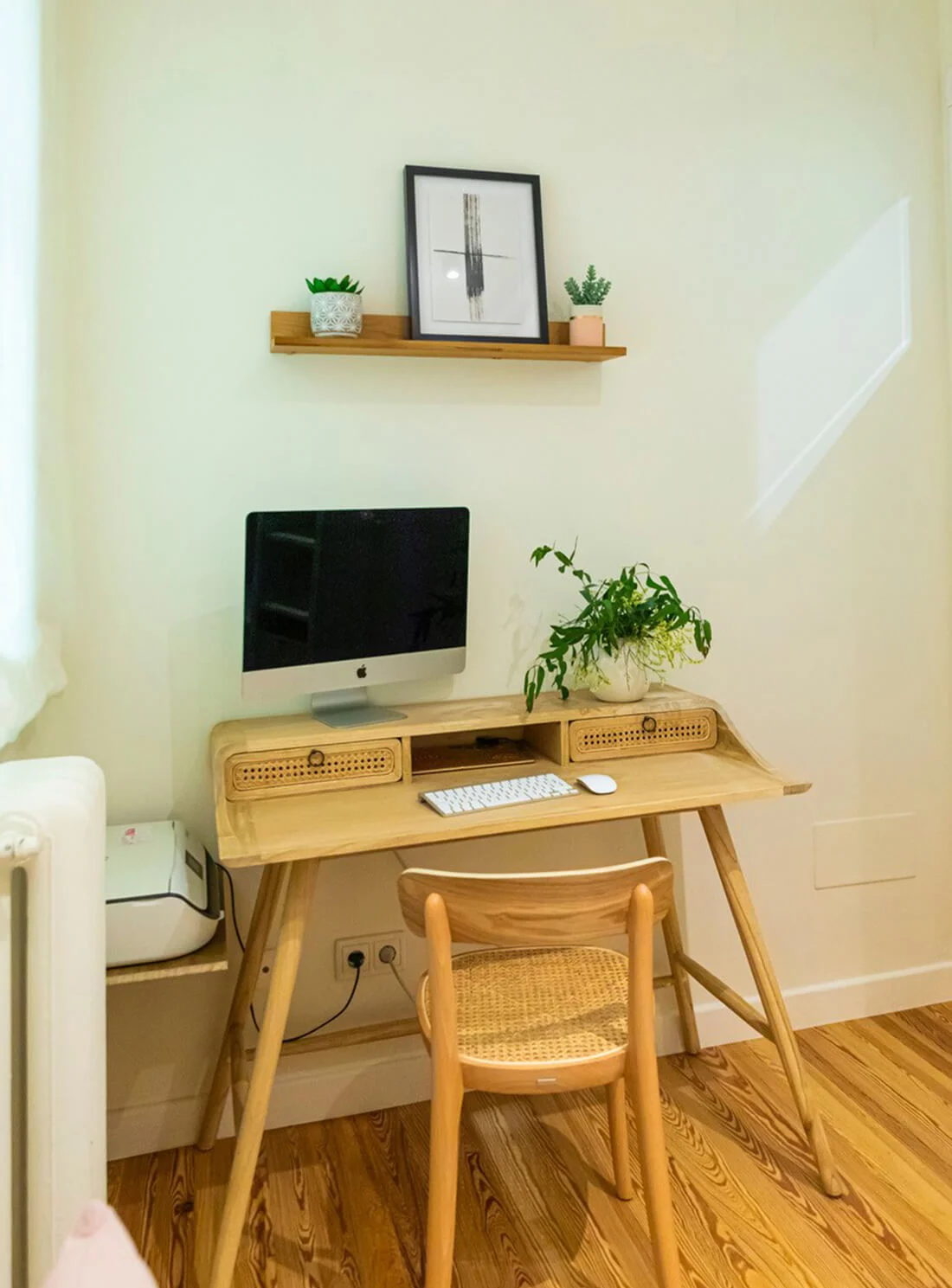 Zona de escritorio de madera con silla, iMac y estante flotante decorativo. Proyecto de decoración de Flor Piñeiro Interiorismo en A Coruña.